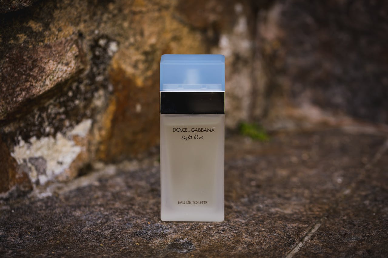 services-03 Dolce & Gabbana Light Blue perfume bottle set against a rustic outdoor background.